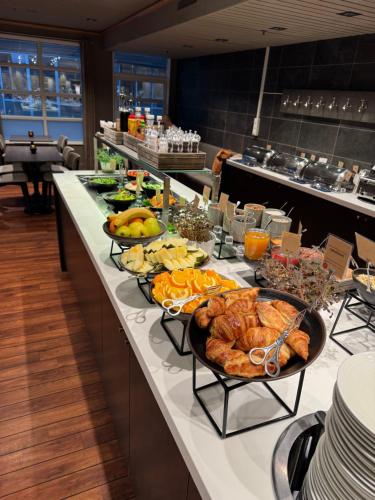 a buffet line with different types of food on it at Home Hotel With in Tromsø