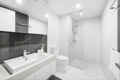 a white bathroom with a sink and a toilet at Central North Braddon – Steps from Cafes & Shops in Braddon
