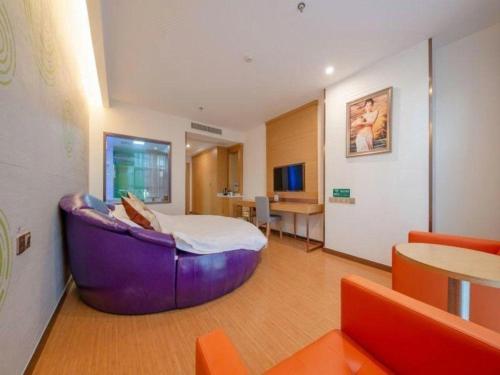 a hotel room with a large purple couch in a room at GreenTree Inn Nantong University Industrial Expo City Express Hotel in Nantong