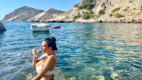 a woman standing in the water in the ocean at Milos Boathouse-Between2seas Boutique in Areti