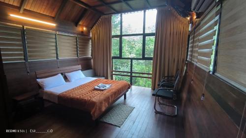 a bedroom with a bed in a room with windows at Fresh Wave Resort And Pool Villa Soochipara in Meppādi