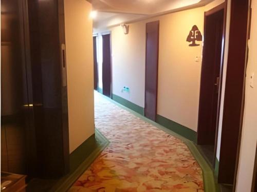 an empty hallway with a floor with a carpet at GreenTree Inn Jiaxing Tongxiang Tudian Express Hotel in Jiaxing