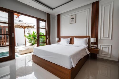 a bedroom with a bed and a large window at Anna Villa Pererenan in Canggu