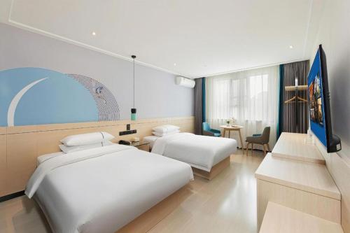 a hotel room with two beds and a television at City Comfort Inn Guilin Railway Station in Guilin
