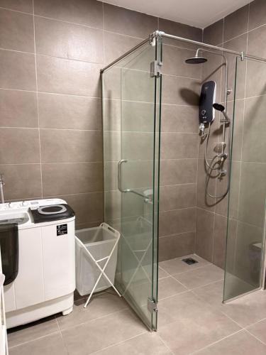 a shower with a glass door in a bathroom at Goldenstay Mutiara Ville Cyberjaya in Cyberjaya