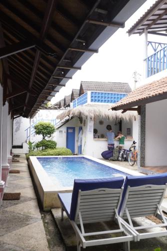 a swimming pool with two lounge chairs next to a building at Seaside Hotel in Gili Trawangan