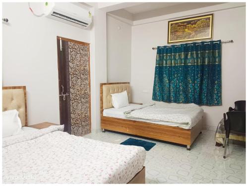 a room with two beds and a window in it at Hotel !! Anand - Palace Near Banaras Railway Station - Offers Budget Rooms With Wi-fi Facility - A Comfort Stay Guest House In Varanasi in Varanasi