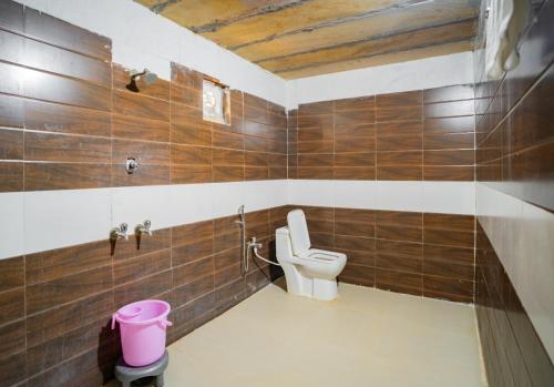 a bathroom with a toilet and a pink trash can at Royal Jaisalmer Resort with Swimming Pool in Jaisalmer