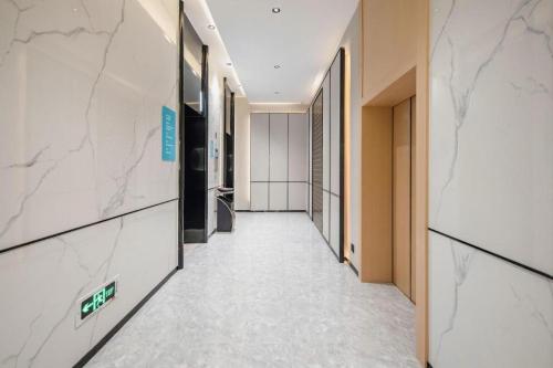 an empty hallway in a building with marble walls at City Comfort Inn Nanning Guangxi University in Nanning