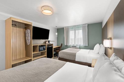 Una habitación de hotel con dos camas y un televisor de pantalla plana. en Quality Inn Atlanta Airport-Central, en Atlanta