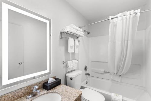 Un baño con inodoro, lavabo y espejo. en Quality Inn Atlanta Airport-Central, en Atlanta