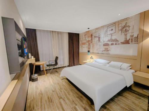 a bedroom with a large white bed and a desk at City Comfort Inn Wuhan Baibuting in Wuhan