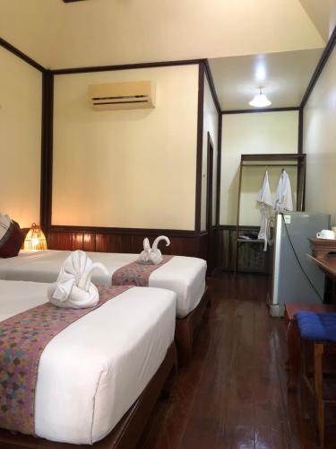 a hotel room with two beds and a mirror at Sengahloune Resort in Ban Khon