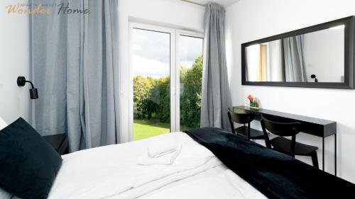 a bedroom with a bed and a desk with a mirror at Wonder Home - Domki Hillside tuż przy stoku narciarskim - na terenie kompleksu plac zabaw i zewnętrzna siłownia, sklep, parking in Karpacz