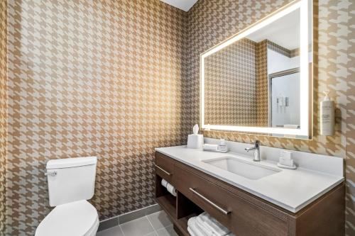 a bathroom with a toilet and a sink and a mirror at Home2 Suites By Hilton Marion in Marion