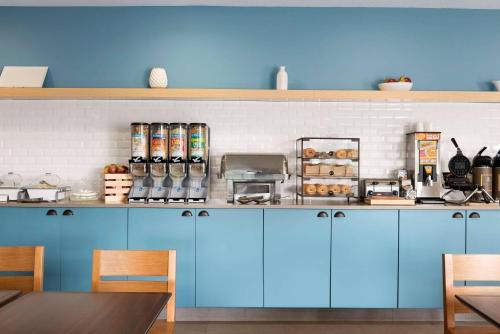 a kitchen with blue cabinets and a counter top at Country Inn & Suites by Radisson, Romeoville - Bolingbrook in Romeoville