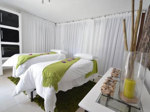 a bedroom with two beds and a table with a vase at ANEW Hotel & Convention Centre OR Tambo Johannesburg in Benoni