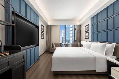 a bedroom with a large bed and a flat screen tv at Days Hotel by Wyndham Urumqi Pingchuan Road in Ürümqi