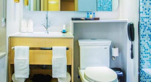 a bathroom with a toilet and a sink at Beluga Sanya Discovery Ocean World in Shangsimacun