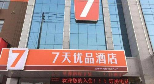 an orange sign in front of a building at 7 Days Premium·Zaozhuang High-speed Railway Station Guangming Xi Road in Taozhuang