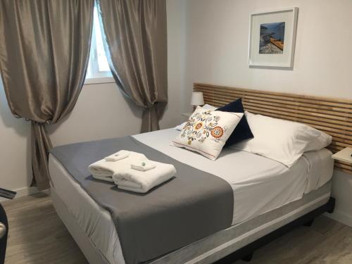 1 dormitorio con 1 cama con toallas en The Inn on College, en Saskatoon