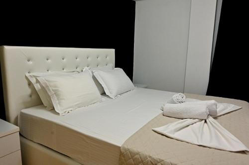 un letto bianco con cuscini e asciugamani bianchi di Zeusplace Black and White Retreat a Kateríni