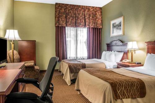 a hotel room with two beds and a chair at Quality Inn & Suites Ann Arbor Hwy 23 in Ann Arbor