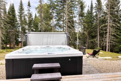 a jacuzzi tub in the middle of a yard at Spa Lakeside & Adventure - Nature Chic in Saint-Michel-des-Saints