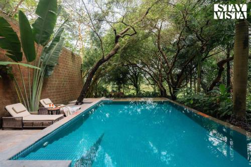 a swimming pool in a yard with trees at StayVista at Moira by the River with Bonfire, BBQ in Moira