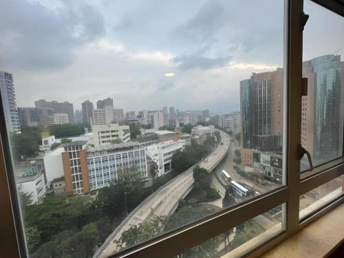 a view of a city from a window at New Mong Kok Guest House in Hong Kong