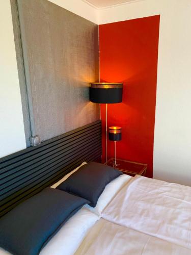a bedroom with a bed and a red wall at Nice apartment in Kværs - kitchen and EV charging in Gråsten