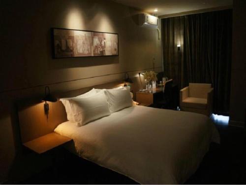 a bedroom with a large bed with white sheets and pillows at Jinjiang Inn Select Shanghai International Tourism and Resorts Zone Chuansha Road Subway Station in Shanghai