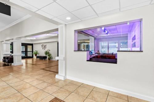 an empty lobby with a tv on a wall at Days Inn & Suites by Wyndham Lakeland in Lakeland