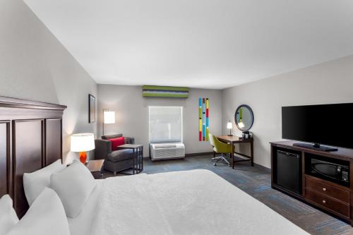 a hotel room with a bed and a flat screen tv at Hampton Inn University Area, Huntington, Wv in Huntington