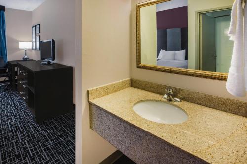 a bathroom with a sink and a mirror at La Quinta Inn by Wyndham Indianapolis North in Indianapolis