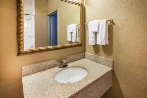 a bathroom with a sink and a mirror and towels at La Quinta Inn by Wyndham Indianapolis North in Indianapolis