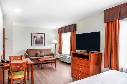 a living room with a television and a couch at Days Inn & Suites by Wyndham Sherwood Park Edmonton in Sherwood Park