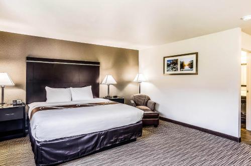 a hotel room with a bed and a chair at Quality Inn & Suites Westminster - Broomfield in Westminster