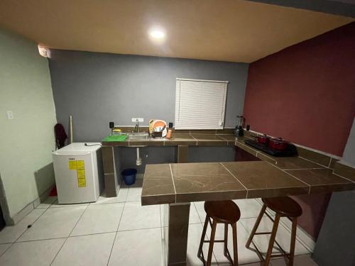 eine Küche mit Theke und zwei Barhockern in der Unterkunft Home Nino in Guadalajara