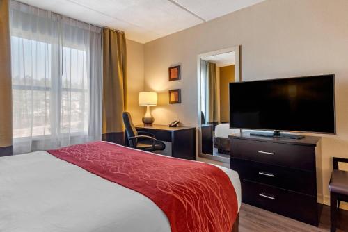 a hotel room with a bed and a flat screen tv at Comfort Inn & Suites near Six Flags in Lithia Springs