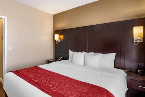 a hotel room with a large bed with a red blanket at Comfort Inn & Suites near Six Flags in Lithia Springs