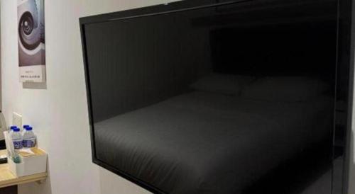 a bed in a room with a black wall at Hotel Zamburger Bentong in Bentong