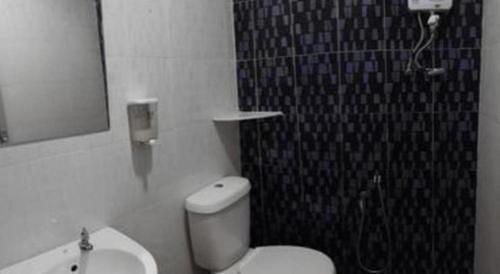 a bathroom with a toilet and a shower and a sink at Hotel Zamburger Bentong in Bentong