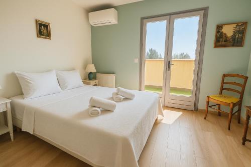 ein Schlafzimmer mit einem weißen Bett mit zwei Handtüchern darauf in der Unterkunft Haut de villa - 5 min du port, terrasse, parking gratuit in Sanary-sur-Mer