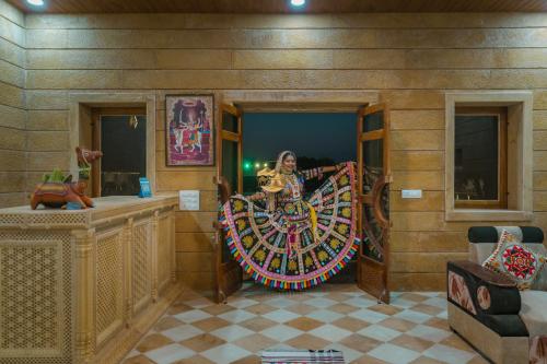 a woman is standing inside of a room with a wheel at Desert Heaven Camp - A Family Luxury Resort Jaisalmer in Jaisalmer