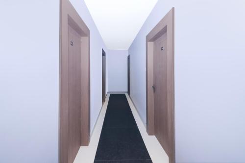an empty hallway with wooden doors and a black rug at Super Collection O Ranchi Station Near Rajendra Chowk Formerly Bodhraj Paradise in Rānchī