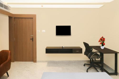 a room with a desk and a television on a wall at Super Collection O Ranchi Station Near Rajendra Chowk Formerly Bodhraj Paradise in Rānchī