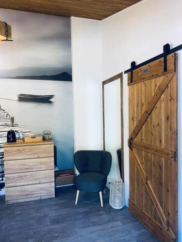 a room with a blue chair and a wooden door at Magnusowe Siedlisko in Budy Chojnackie