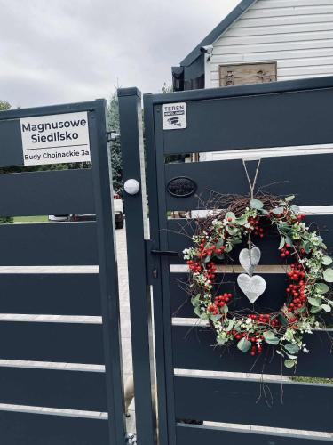 a blue gate with a wreath and a heart on it at Magnusowe Siedlisko in Budy Chojnackie