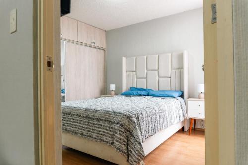 ein Schlafzimmer mit einem großen Bett mit blauen Kissen in der Unterkunft Flat Equipado Callao Cerca al Aeropueto Jorge Chávez 2 Dormitorios in Lima